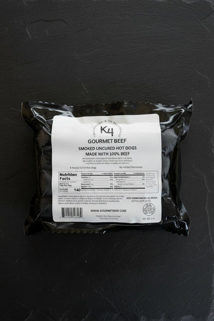 Black package of Smoked Uncured All Beef Hot Dogs on a dark surface