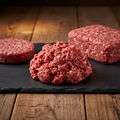 Fresh raw 80/20 ground beef as a patty, loose pile, and block on a dark slate board